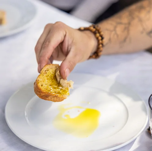Man dipping bread in olive oil